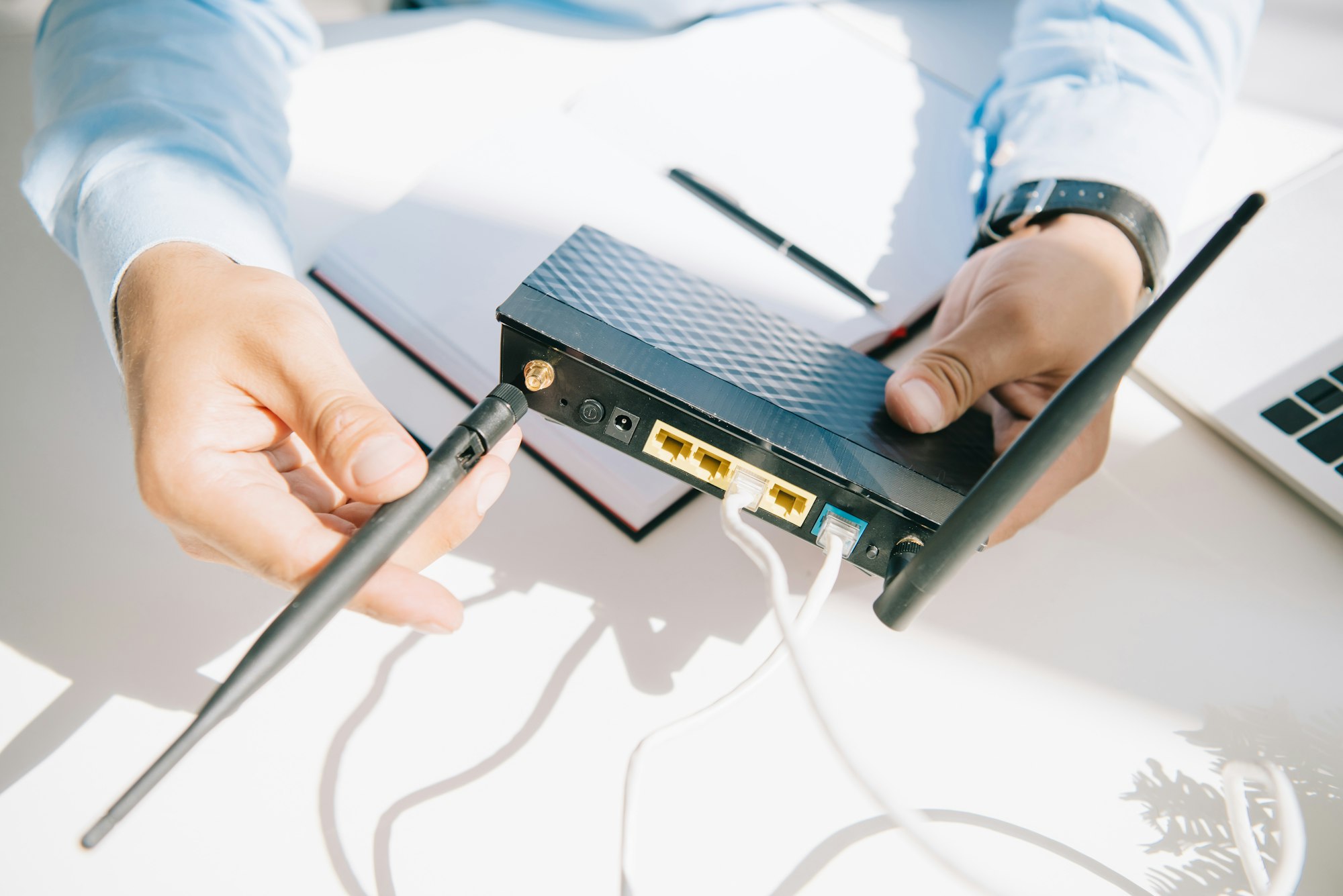 cropped view of businessman adjusting antenna of router